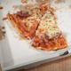 two slices of pizza in delivery box